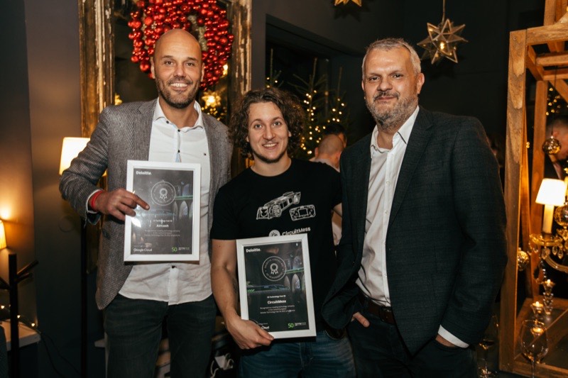 Albert Gajšak holding a Deloitte award certificate at an evening ceremony with two other people.