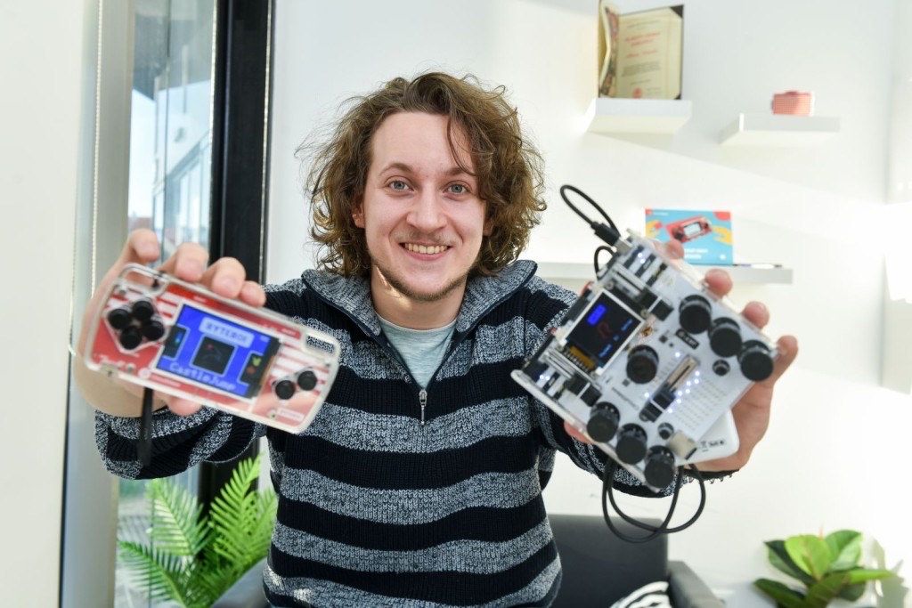 Albert Gajšak holding up two assembled CircuitMess kits, one in each hand.